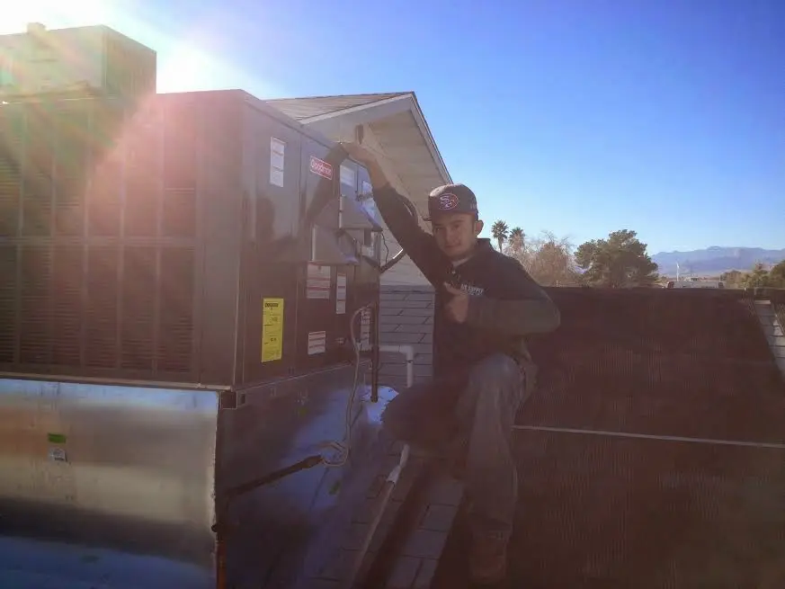 HVAC technician performing AC Tune-Up on a rooftop unit in Atoka